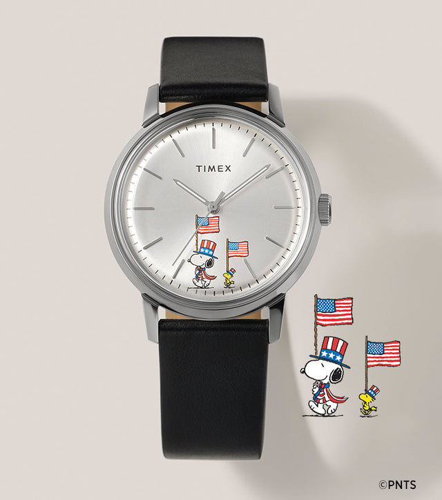 Timex Marlin Automatic x Peanuts Americana watch with silver dial, black leather strap, and Snoopy and Woodstock holding American flags