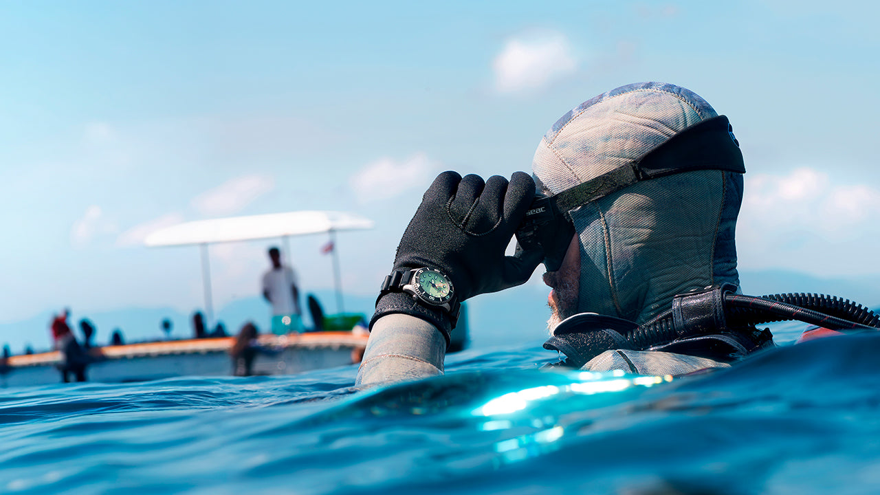 Professional diver wearing the Timex Deepwater Meridian 300 Titanium HEV Automatic while observing the ocean from the water's surface.