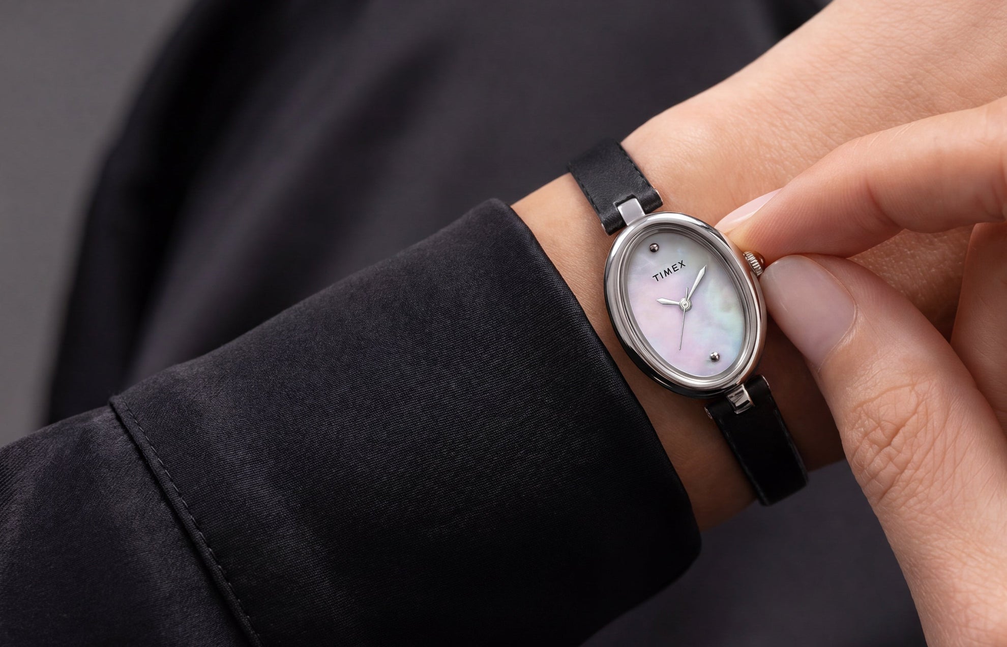 Timex Cavatina® Luxe silver-tone watch with a mother-of-pearl dial and black leather strap worn on the wrist.