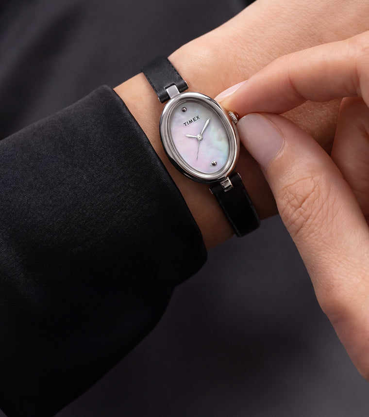 Timex Cavatina® Luxe silver-tone watch with a mother-of-pearl dial and black leather strap worn on the wrist.