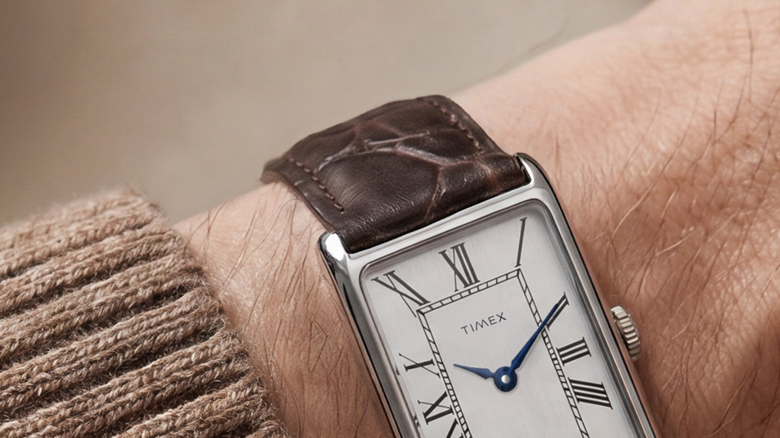 Close-up of the Timex 1976 Lexington Reissue Inspired watch worn on the wrist with a brown crocodile-grain leather strap and rectangular silver-tone case.