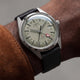 Timex Marlin® Jet Titanium Automatic GMT worn on wrist, featuring a lightweight titanium case, cream dial, red GMT hand, and black leather strap.