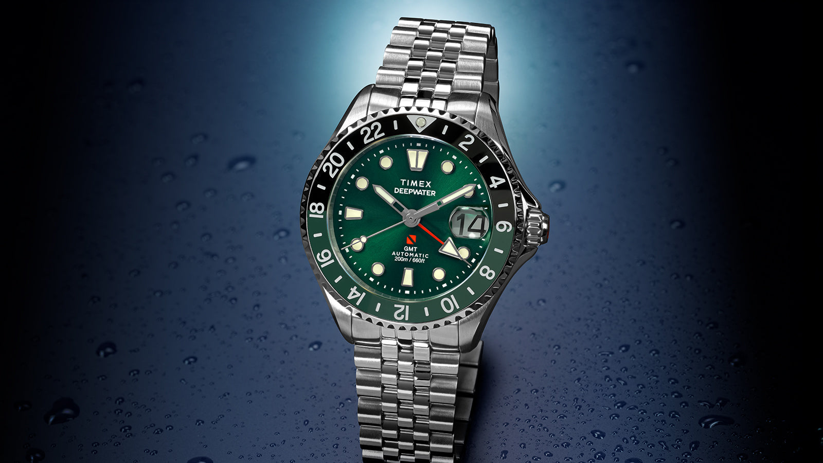 Front-facing view of the Timex Deepwater Meridian 200 Automatic GMT with a green dial, GMT bezel, magnified date display, and stainless steel bracelet.