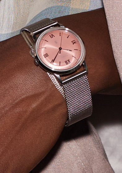 Todd Snyder x Timex Marlin® Mesh watch with a pink dial and stainless steel mesh bracelet worn with a pastel suit, patterned shirt, and statement ring.