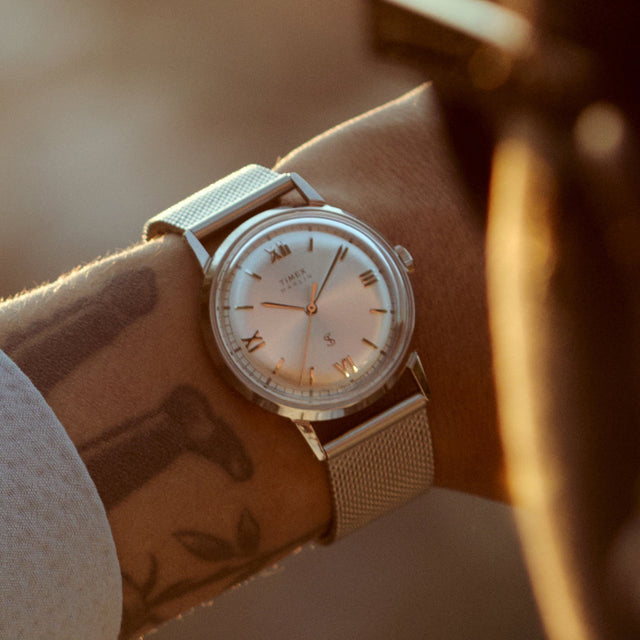 Close-up of the Todd Snyder x Timex Marlin® Mesh watch with a silver sunray dial and stainless steel mesh bracelet worn on the wrist.