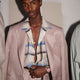 Person wearing the Todd Snyder x Timex Marlin® Mesh watch with a pink dial, paired with a pastel suit and plaid shirt.