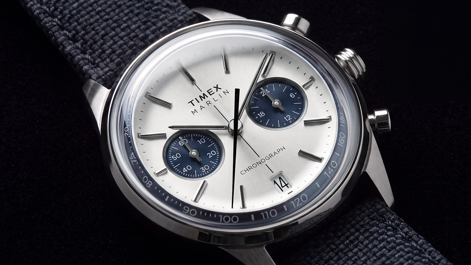 Close-up of the Timex Marlin® Jet Chronograph showing its silver-tone dial, blue subdials, date window, and blue tachymeter scale.