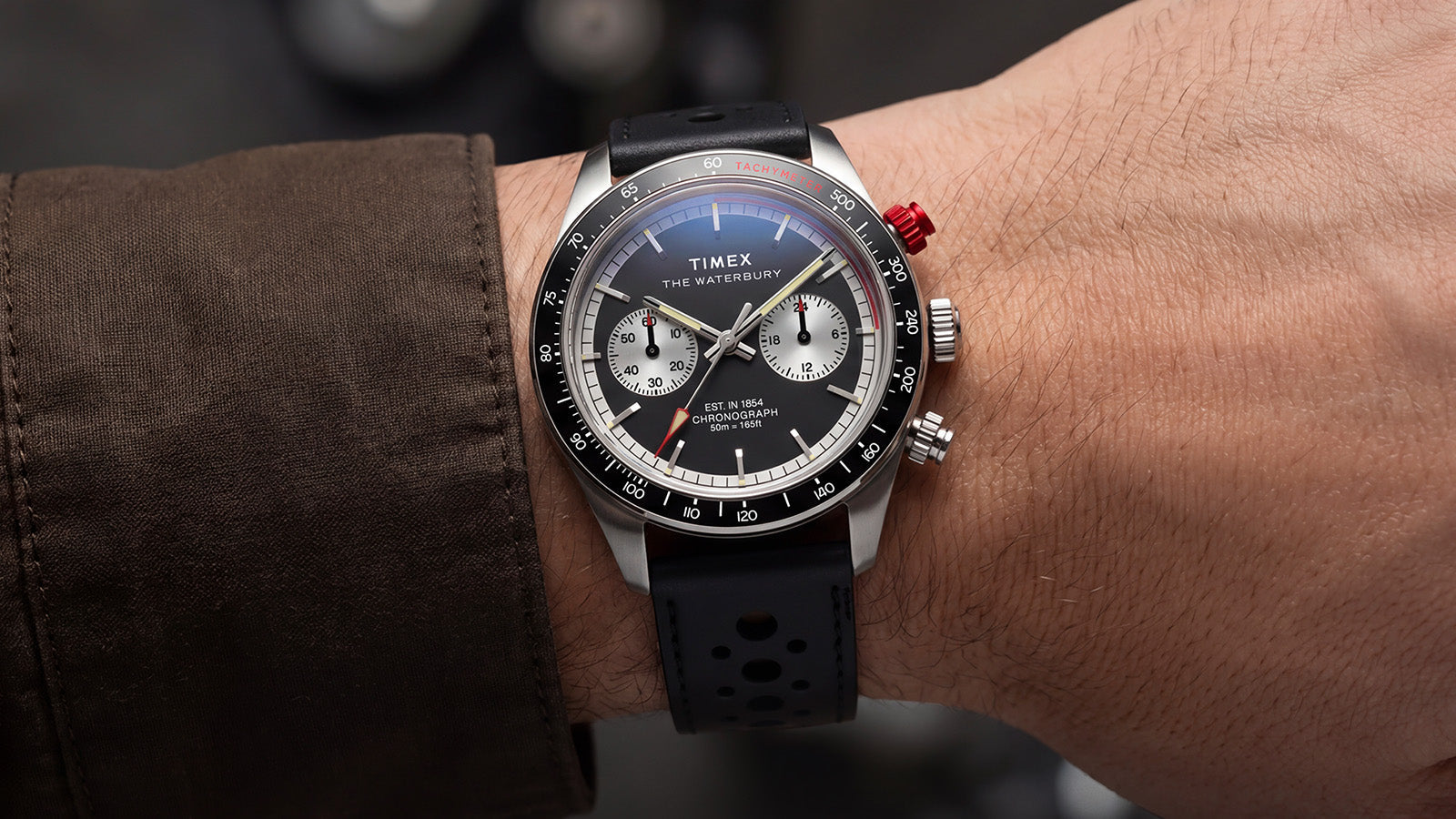 Timex Waterbury Heritage Chronograph with a black leather racing strap and panda-style chronograph dial worn on the wrist.