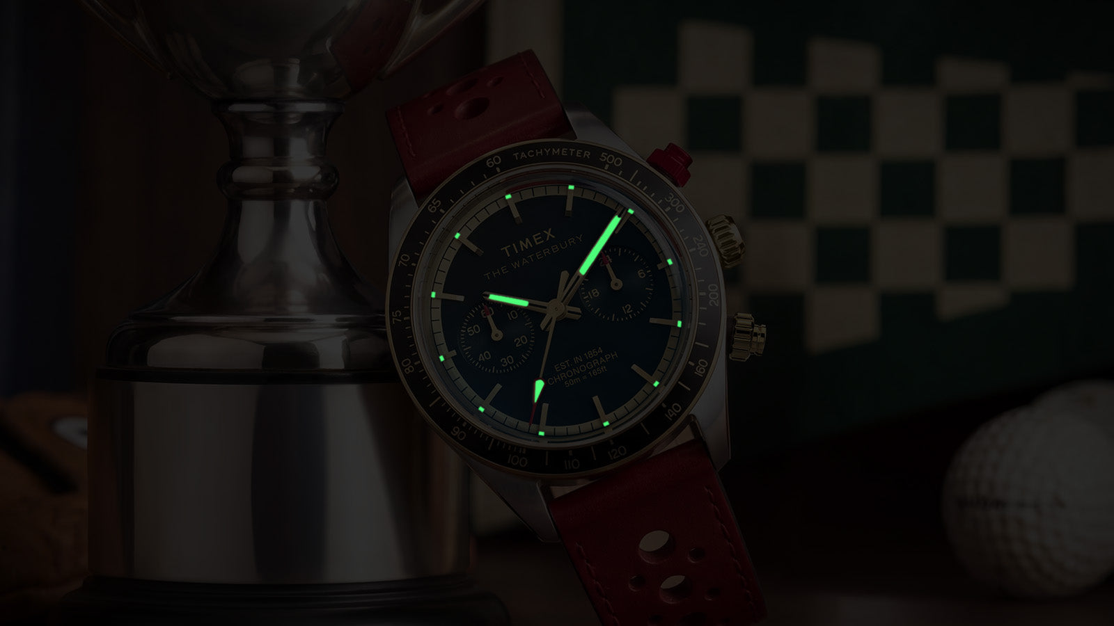 Timex Waterbury Heritage Chronograph with luminous hands and hour markers glowing in low light.