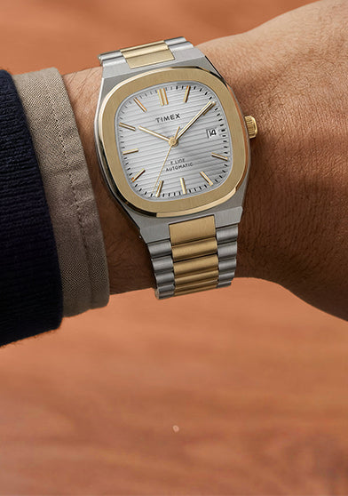 Timex Automatic E Line 38mm with a silver-tone dial and two-tone stainless-steel bracelet, shown on the wrist.