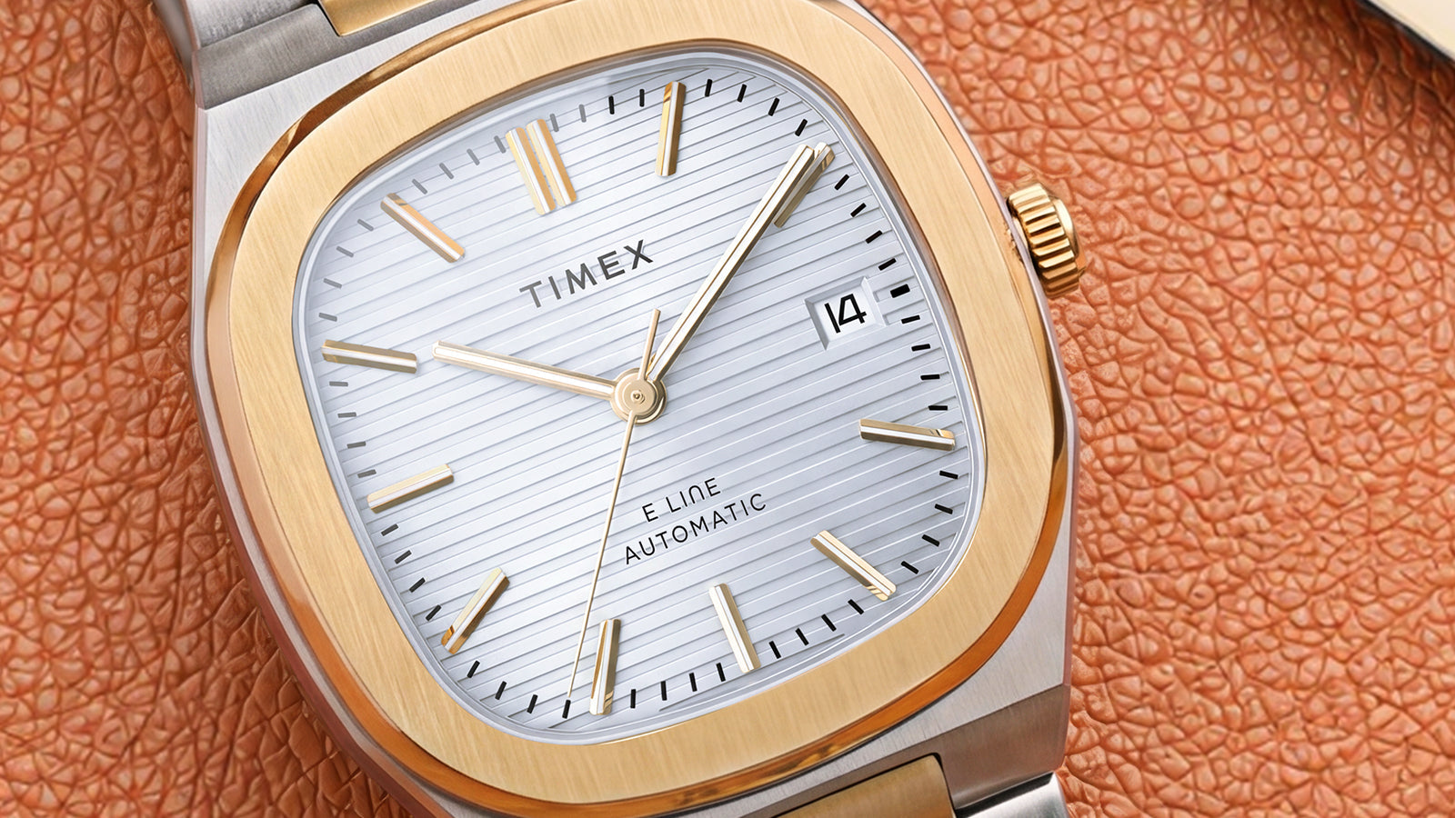 Close-up of the Timex® Automatic E Line 38mm featuring a silver textured dial, gold-tone bezel, date window, and two-tone stainless steel bracelet.