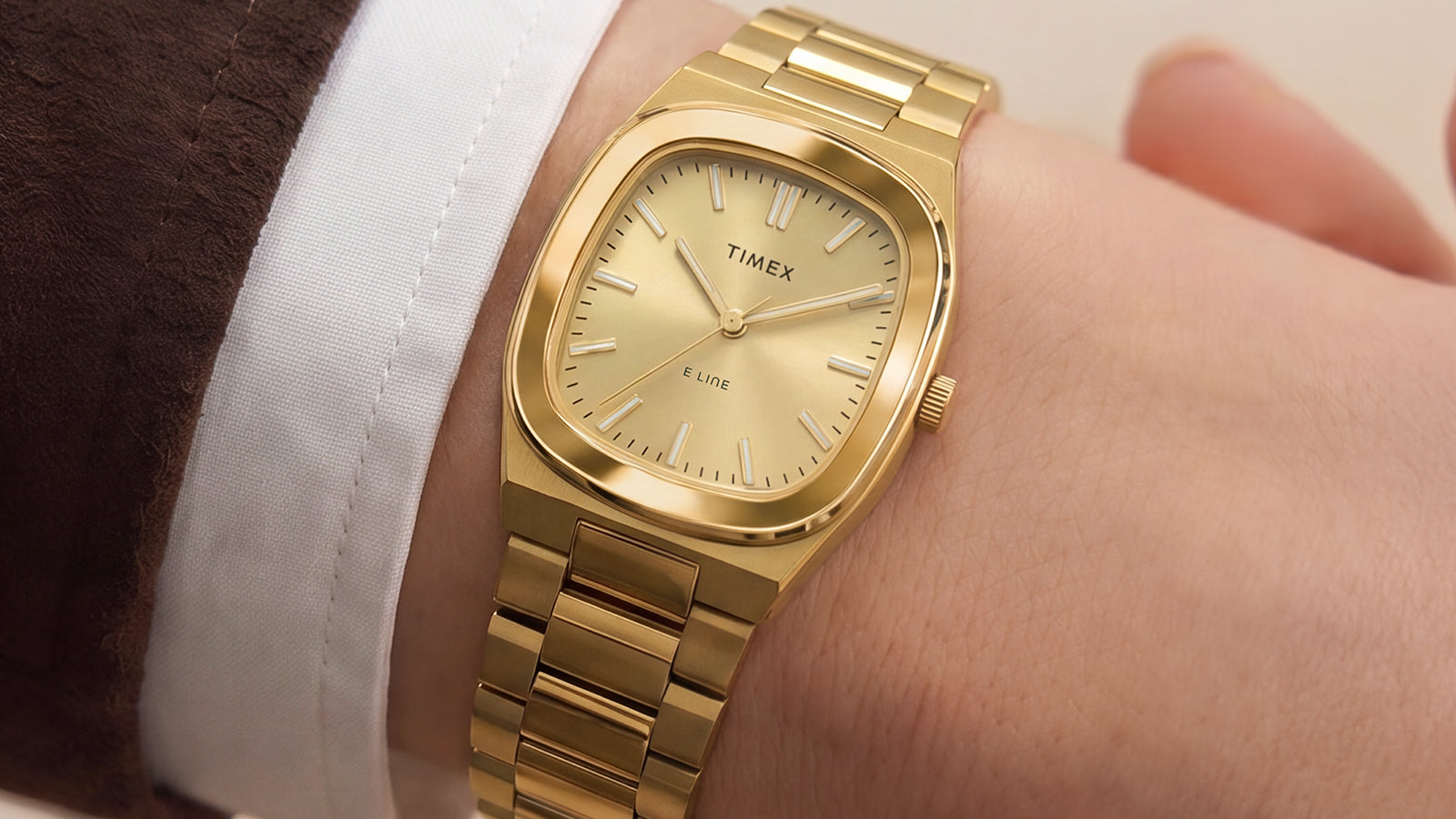 Timex® Quartz E Line 30mm gold-tone stainless steel watch with a champagne dial worn on the wrist.