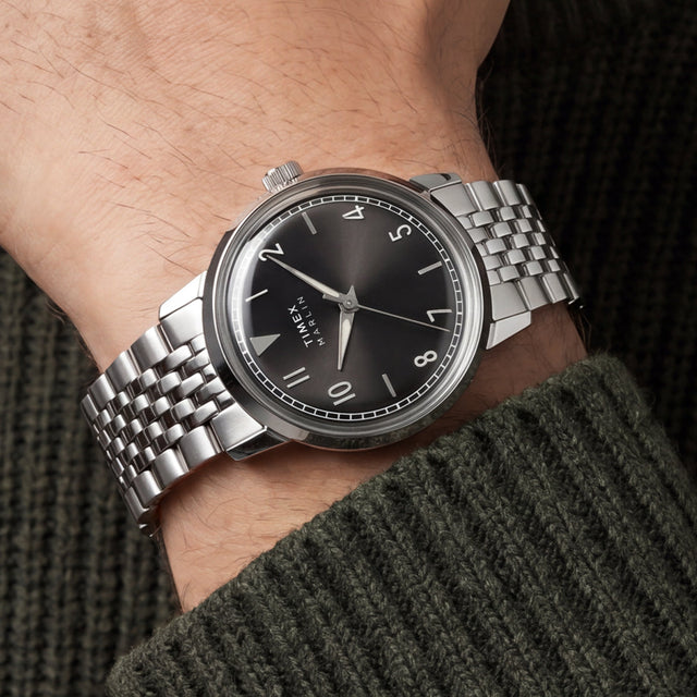 Timex Marlin Quartz with a black sunray dial and stainless steel bracelet worn on the wrist.