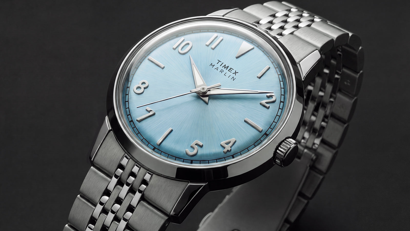Close-up of the Timex Marlin Quartz featuring an ice blue sunray dial, applied silver-tone hour markers, polished stainless steel case, and stainless steel bracelet.