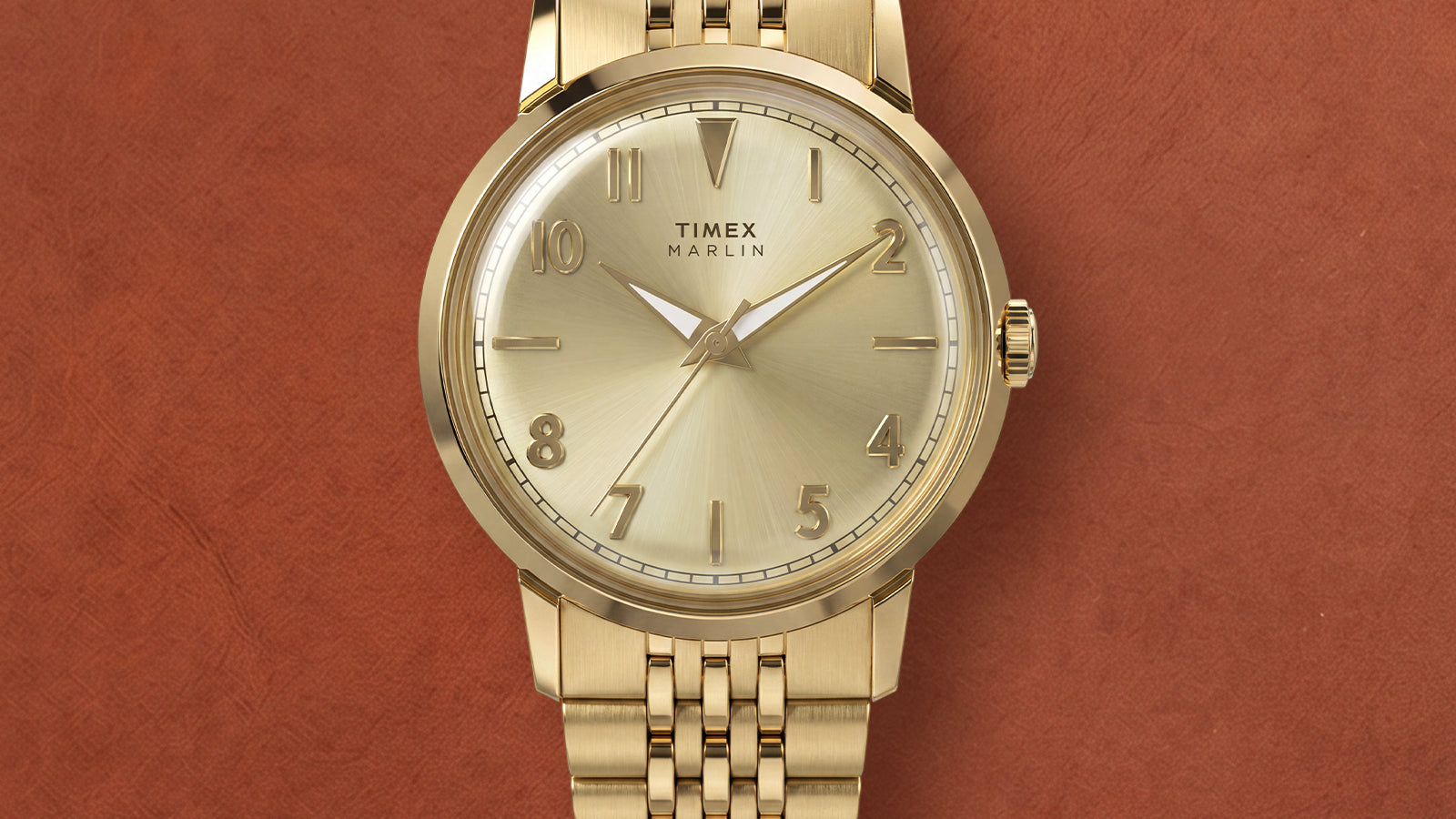 Close-up of the Timex Marlin Quartz featuring a champagne sunray dial, applied gold-tone Arabic numerals, polished gold-tone case, and gold-tone stainless steel bracelet.