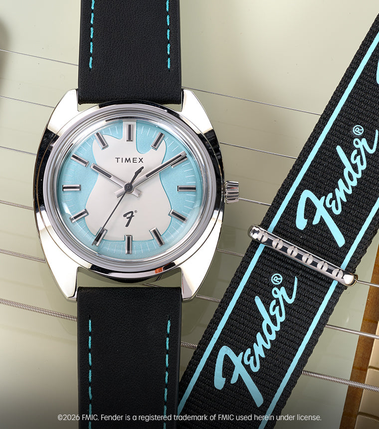 Fender x Timex watch with a silver-tone case, aqua-accented dial, and black strap displayed across a Fender electric guitar.
