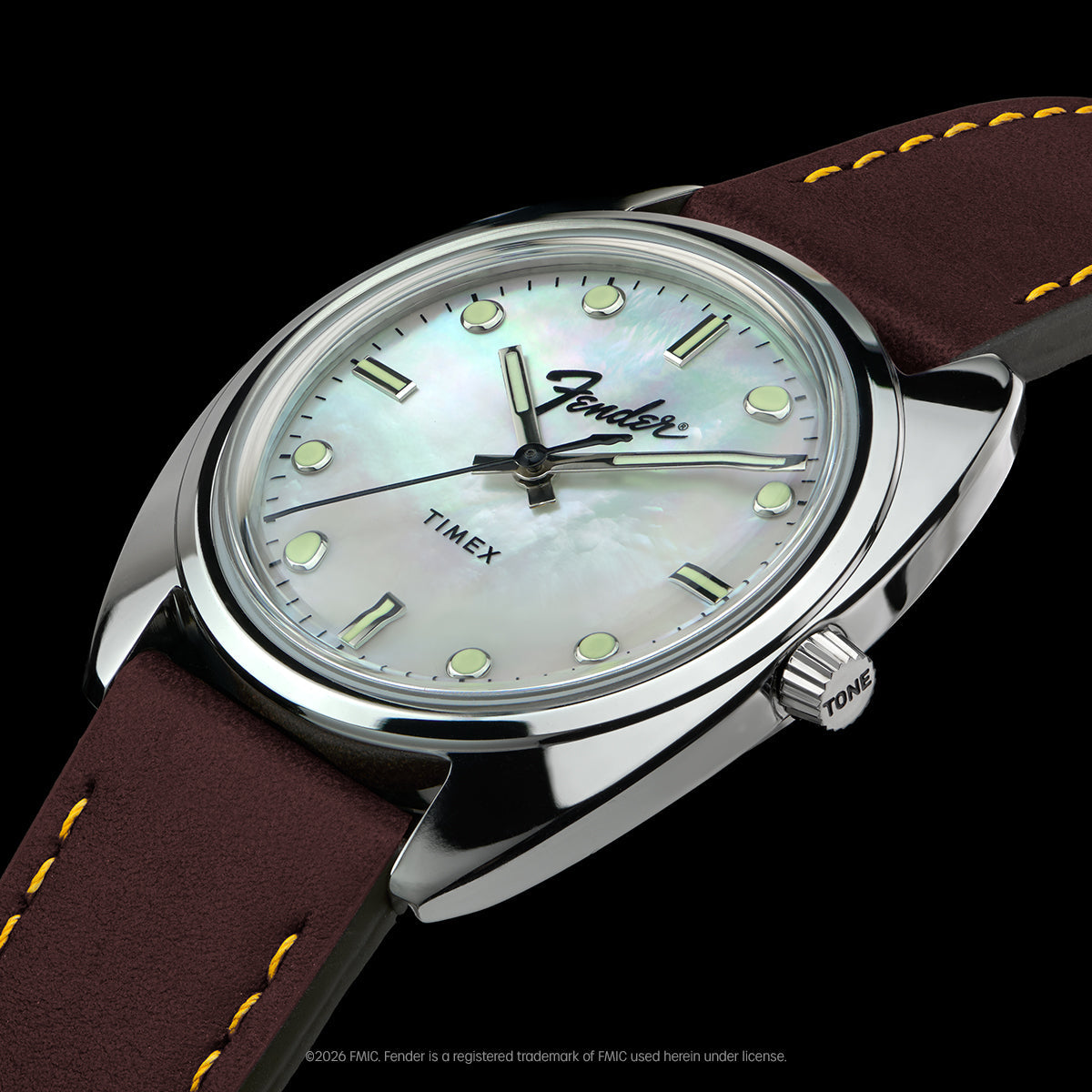 Angled close-up of the Fender x Timex watch highlighting its mother-of-pearl dial, brown leather strap, and tone-inspired crown.