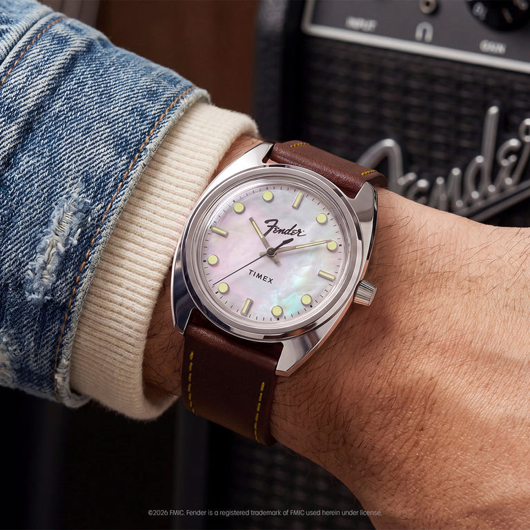 Fender x Timex watch worn on the wrist with a Fender amplifier in the background.
