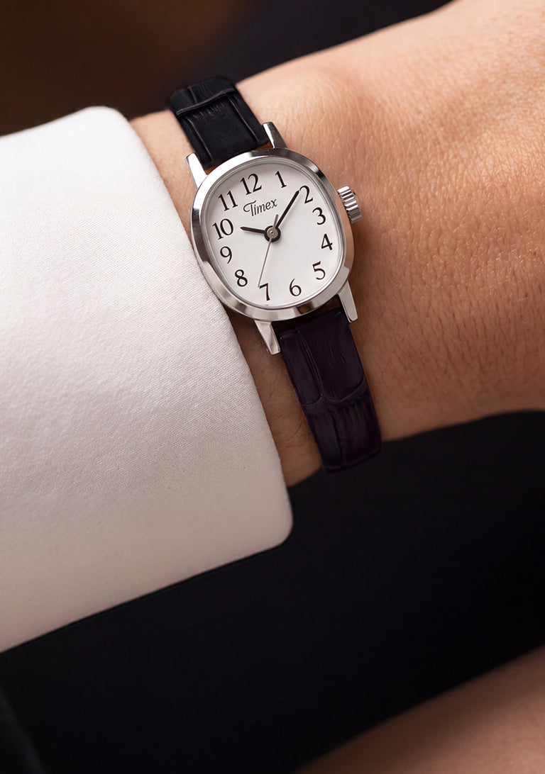 Cavatina® Mini watch with a white dial and black leather strap worn on a wrist.