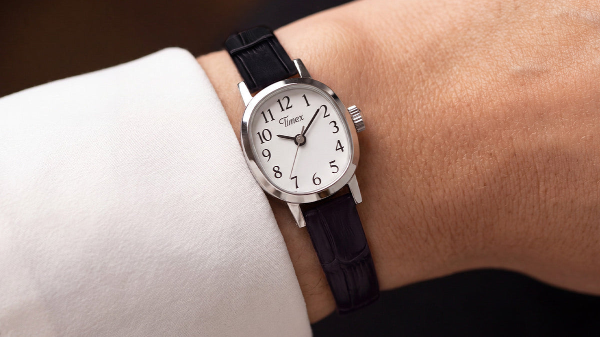 Close-up of the Cavatina® Mini with a black leather strap worn on a wrist beneath a white sleeve.