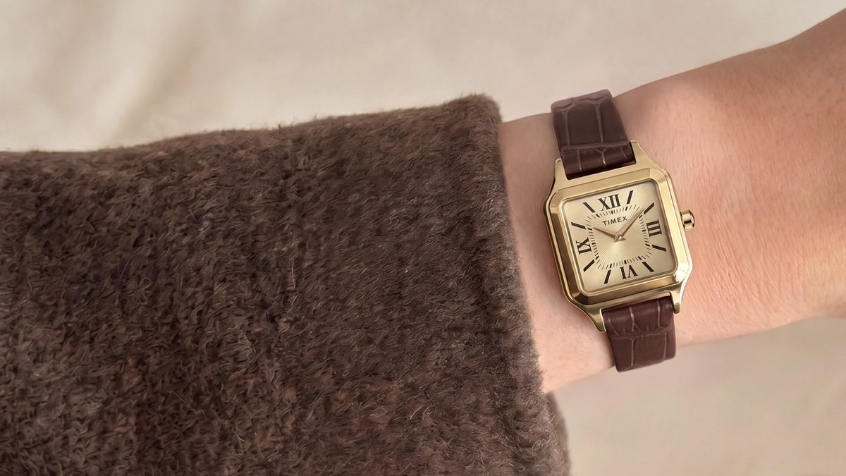 Close-up of the Timex Addison watch styled on the wrist with a soft brown sweater.