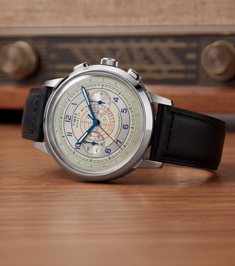Marlin® Neo Classic Chronograph with a cream multiscale dial and black leather strap displayed on a wooden surface beside a vintage radio.