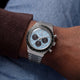 Ice-blue Q Timex Chronograph with black subdials and a stainless-steel bracelet worn on the wrist.