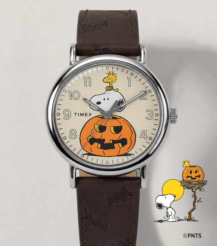 Peanuts® x Timex Weekender® Pumpkin watch with a brown leather strap and a cream dial featuring Snoopy, Woodstock, and a jack-o’-lantern.