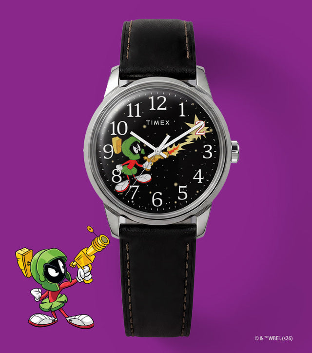TW2Y99300 Looney Tunes Marvin the Martian x Timex Easy Reader® watch with a black character dial and black leather strap beside Marvin artwork on purple.