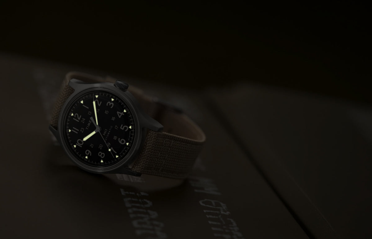 MK1® Automatic watch in low light, highlighting its luminous hands and hour markers.