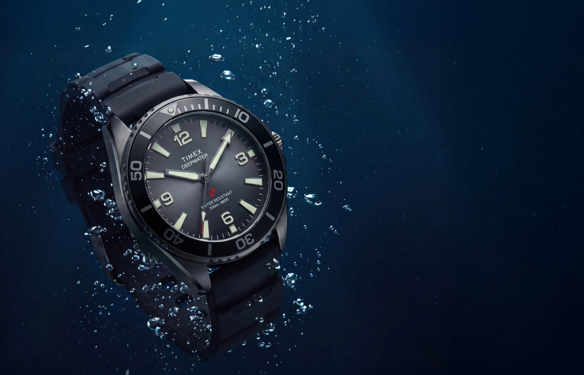 TW3A02000 Deepwater Arctic 200 watch with a gray dial and black strap surrounded by underwater bubbles.
