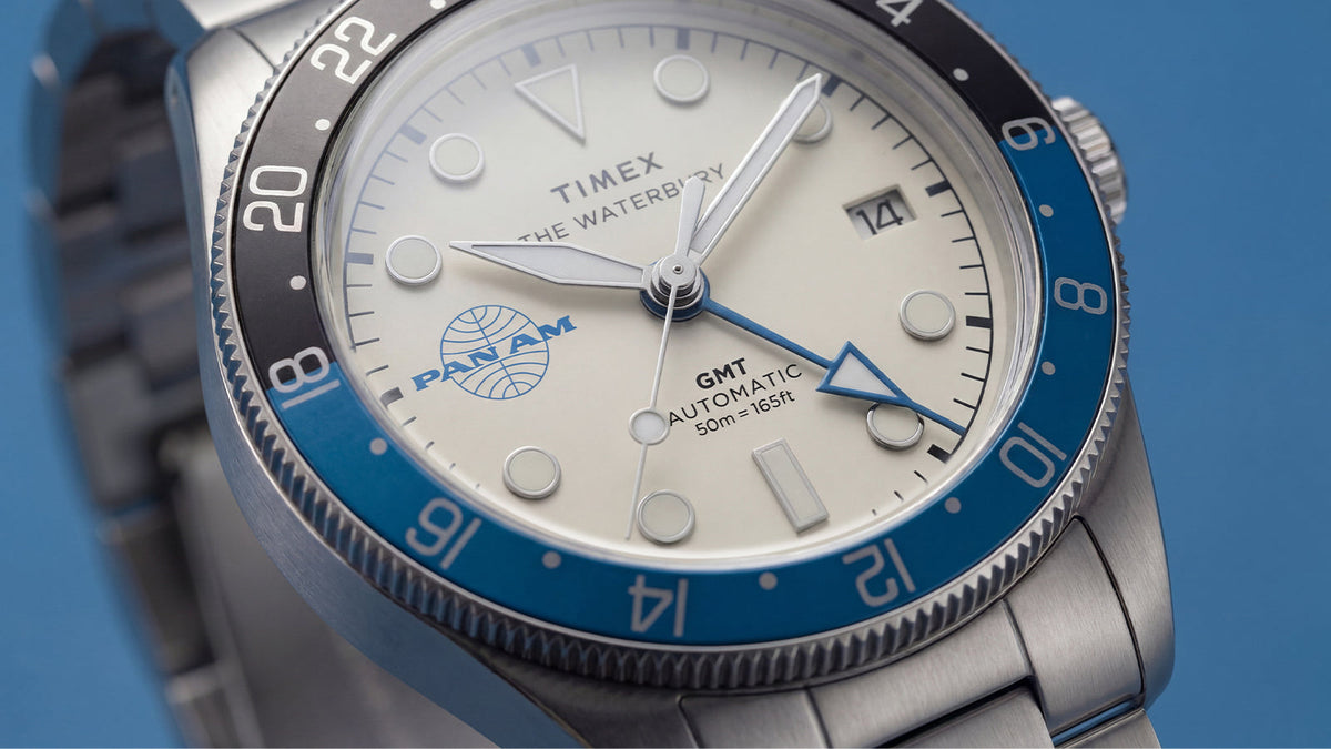 TW2Y94300 Close-up of the watch’s cream dial, blue GMT hand, date window, and two-tone 24-hour bezel.