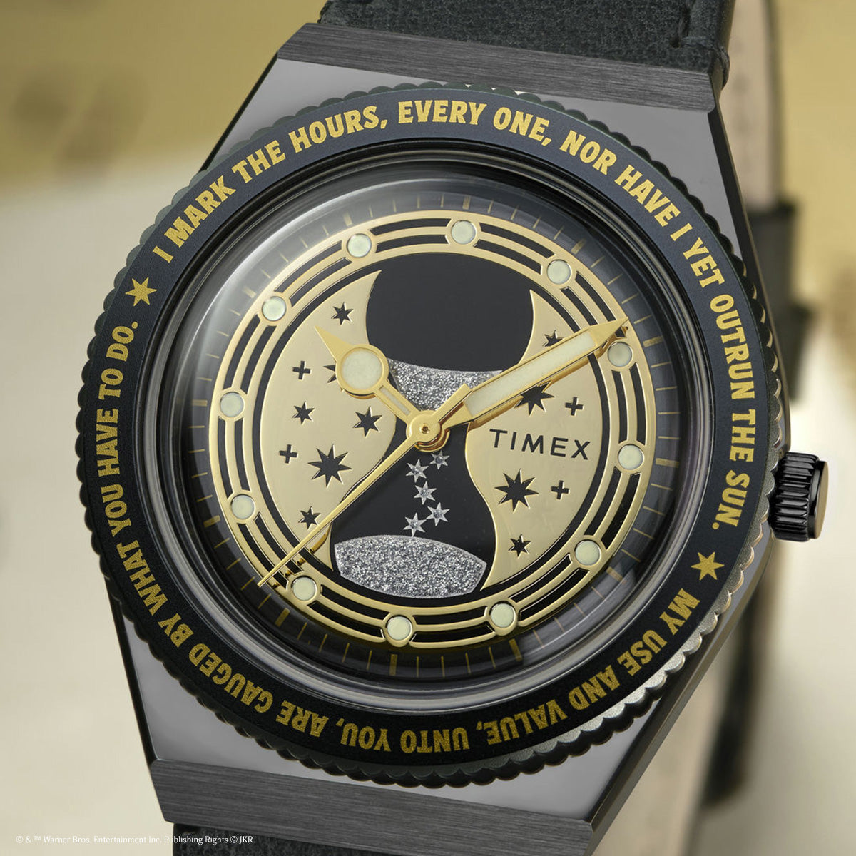 TW2Y76000 Close-up of the watch face, showing the gold hourglass, stars, black case, and gold lettering around the bezel.