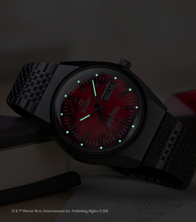 TW2Y99700 Harry Potter x Q Timex watch in low light, highlighting the glowing hands and hour markers on the red dial.
