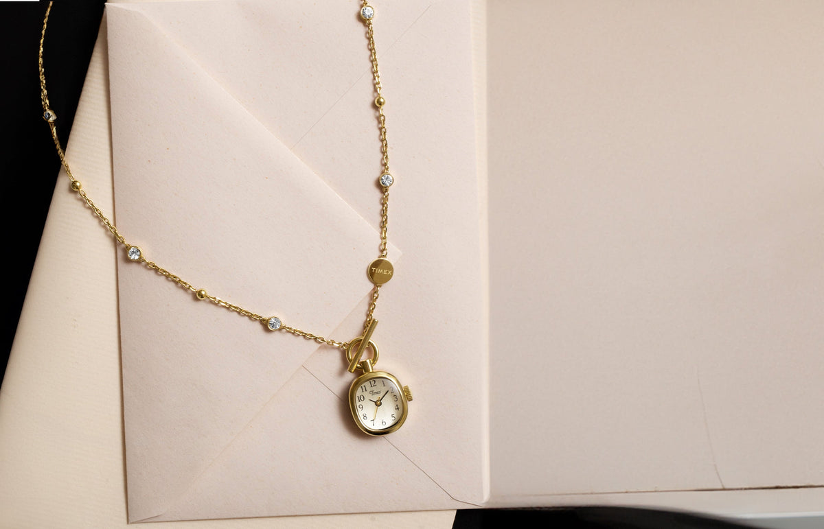 TW6A17700 Gold-tone Cavatina® Mini watch necklace with clear stones and a toggle clasp, displayed on cream stationery.