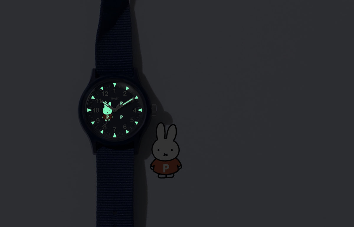 TW6A31000 Pop & Miffy by Timex MK1 watch with green glowing hands, hour markers and Miffy dial details, beside a Miffy illustration.