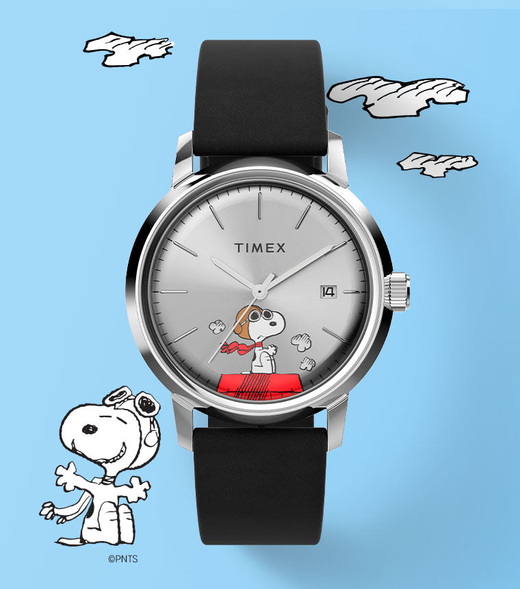 A playful and stylish image featuring the Timex Snoopy Flying Ace watch against a light blue background with cartoon-style clouds. The watch has a silver dial with an illustration of Snoopy dressed as a World War I flying ace, sitting atop his iconic red doghouse. The black strap complements the sleek design. To the left, an additional Snoopy illustration adds charm to the composition. The layout emphasizes the aviation theme while maintaining a clean and modern aesthetic.