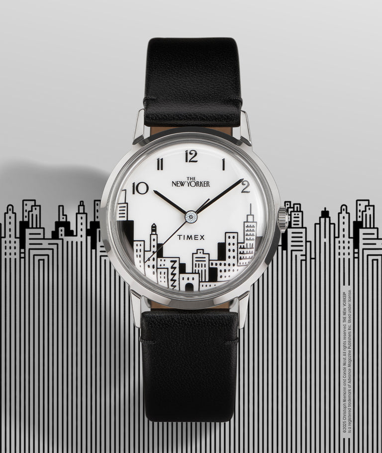 A Timex x The New Yorker Marlin® Hand-Wound watch is displayed against a background featuring a stylized black-and-white cityscape illustration. The watch dial mirrors this skyline design, with bold black outlines of buildings at the bottom. The watch has a polished stainless-steel case, black leather strap, and classic Arabic numerals at the 12, 2, and 10 o’clock positions. "The New Yorker" logo is featured beneath the 12 o’clock mark, and "Timex" is centered on the dial. The backdrop enhances the urban ae