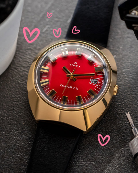 Q 1972 Reissue with Red Dial featured on a  dark bakground with hearts