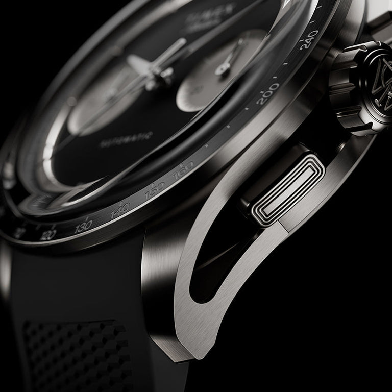 Macro view of Timex Atelier Chronograph Automatic Ti M1a titanium case, crown, and chronograph pusher with rubber strap