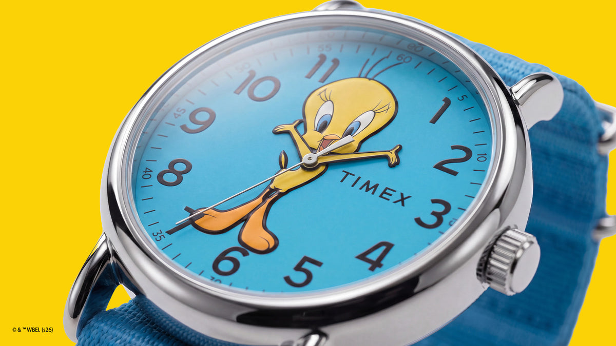 TW2Y99500 Angled close-up of the Tweety Bird x Timex Weekender watch showing its colorful character dial, polished silver-tone case, and crown.