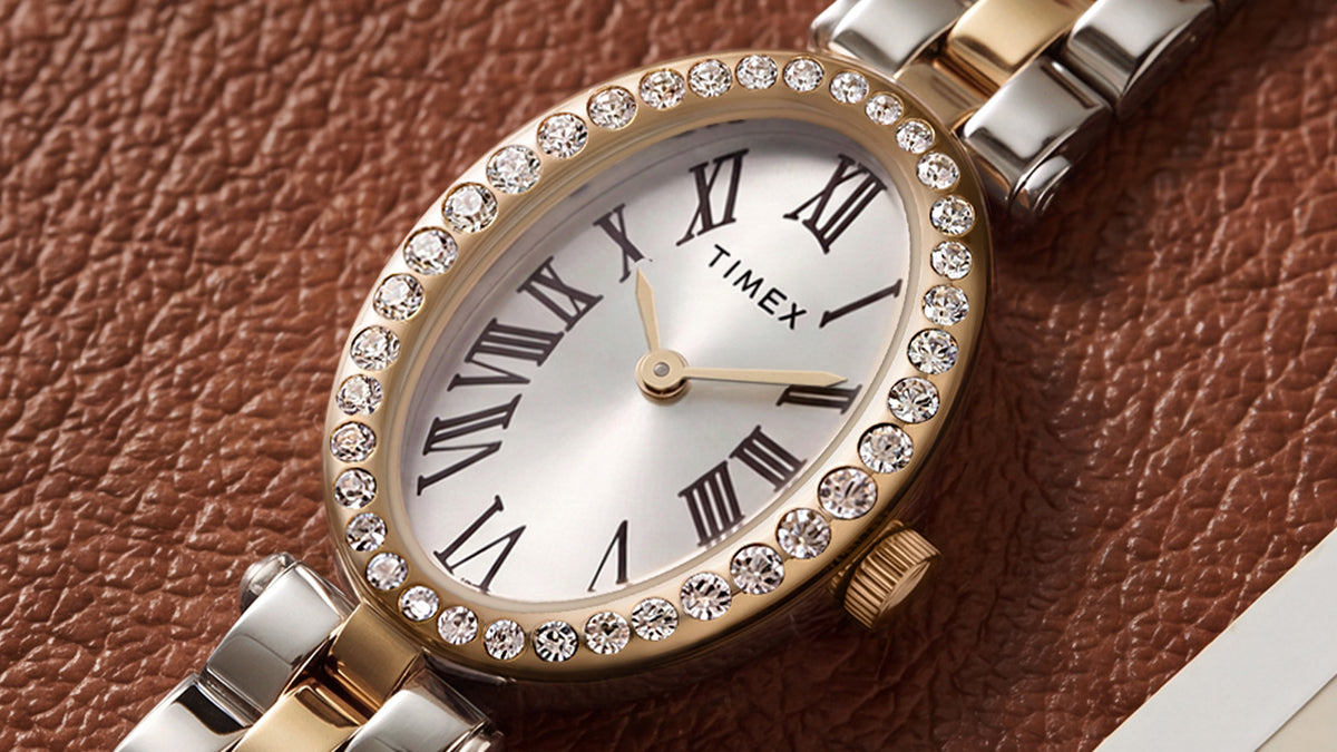 TW2Y90200 Close-up of the Timex Cavatina® Crystals watch’s silver-tone dial, black Roman numerals, gold-tone hands, and crystal-lined oval bezel.