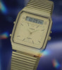 A close-up cinematic video of the Q Timex® 1982 Ana-Digi Reissue watch. The watch features a sleek stainless steel case and bracelet, with a dual analog-digital display. The analog hands move smoothly over the black dial, which includes a digital screen displaying time, date, and additional functions. The camera captures intricate details of the watch face, including the textured bezel and polished metal finish. The lighting shifts dynamically, emphasizing the craftsmanship and vintage-inspired design.