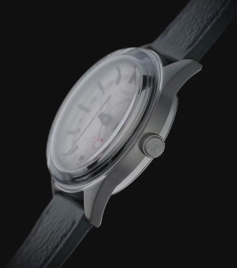 Marlin® Jet Titanium Automatic GMT watch rotating against a black background, highlighting its lightweight titanium case, silver-tone dial with 24-hour GMT scale, red GMT hand, black textured leather strap, side profile, and polished finishing from multiple angles before ending with a full front view.