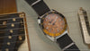 Fender x Timex Automatic shown through rotating close-ups of its wood-grain dial, silver-tone case, black strap, and guitar-inspired details.
